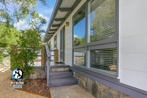 A modern building with a stone foundation, large windows, and a welcoming entrance with steps.