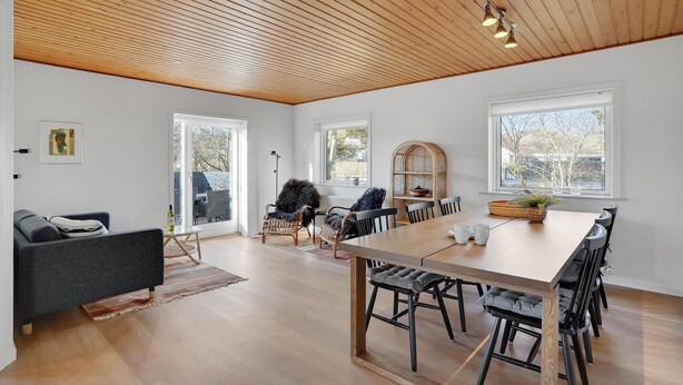 A spacious living room with a large wooden ceiling, a dining area with a long table and chairs, and a cozy seating area with a sofa and chairs. - Amazing home in Nørre Nebel with WiFi (Nørre Nebel)