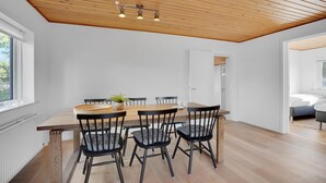 A dining area with a wooden table and chairs, a ceiling with exposed beams, and a view into another room. - Amazing home in Nørre Nebel with WiFi (Nørre Nebel)