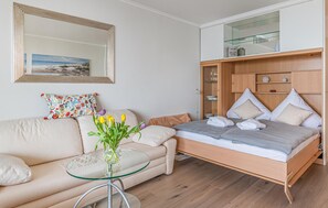 Ein modernes Schlafzimmer mit einem Bett, einem Glastisch, einer Couch und einem Spiegel.