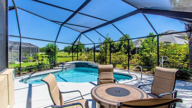 A screened outdoor area with a pool, chairs, and a table. - Beautiful Water/Golfview 3 BR pool home,  located in the center of the Villages (The Villages)