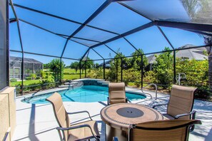 A screened outdoor area with a pool, chairs, and a table. - Beautiful Water/Golfview 3 BR pool home,  located in the center of the Villages (The Villages)