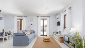 A modern living room with a sofa, a dining table, and a TV. - Awesome home in Betiga (Betiga)