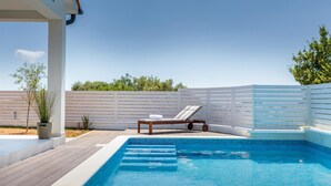 A swimming pool with a wooden deck, a lounge chair, and a white fence. - Awesome home in Betiga (Betiga)