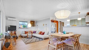 Ein modernes Wohnzimmer mit einer Couch, einem Couchtisch und einem Essbereich.