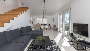 A modern living room with a grey sectional sofa, a black coffee table, and a TV on a stand. - 3 bedroom gorgeous home in Crikvenica (Crikvenica)