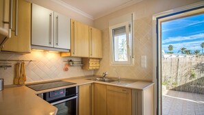 Een praktische keuken met een Bosch oven, een spoelbak en houten kastjes.