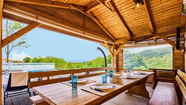 Ein Holz-Essbereich im Freien mit Tisch für Zwei mit Blick auf eine reizvolle Landschaft.