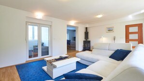 Ein modernes Wohnzimmer mit einem weißen Sofa, einem Couchtisch und einem Kamin.