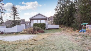 A single-story house with a sloped roof, a front porch, and a small deck. - 3 bedroom lovely home in Helvik (Helvik)