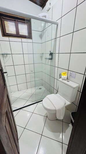 Kylpyhuone, jossa on lasiseinällä varustettu suihku, wc ja pesuallas.
