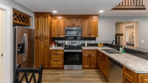 Una cocina moderna con armarios de madera, electrodomésticos de acero inoxidable y encimera de granito.