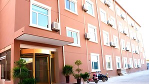 A multi-story hotel with a modern facade, large windows, and a central entrance with a glass door. - Greentree Inn Express Hotel (Guangzhou Road, Heze Development Zone) (Heze)