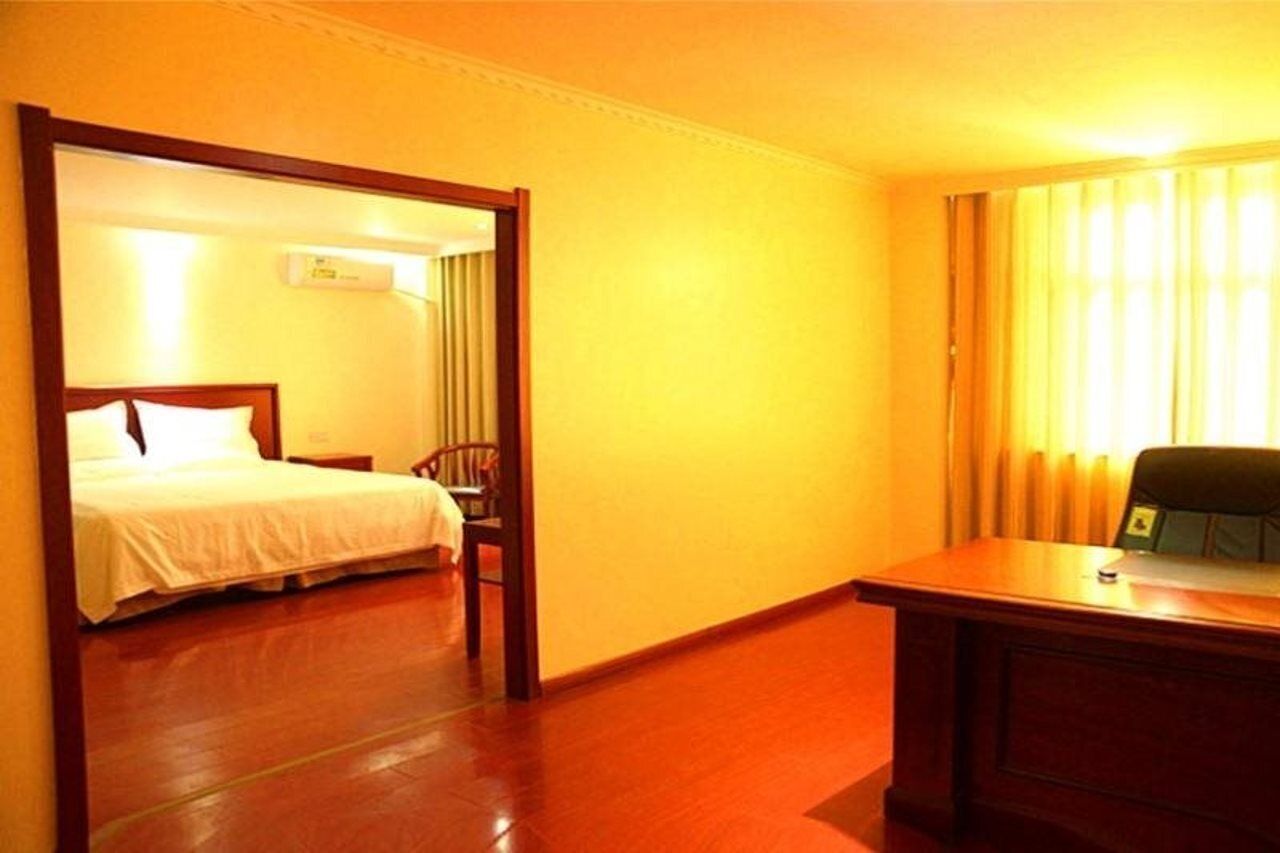 A hotel room with a bed, a desk, and a chair.