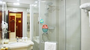 A hotel bathroom with a glass-enclosed shower, a sink with toiletries, and a towel rack. - Greentree Inn Express Hotel (Guangzhou Road, Heze Development Zone) (Heze)