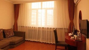 A room with a sofa, a chair, a desk with a computer, and a TV. - Greentree Inn Chifeng Linxi Ronglin Homeland Express Hotel (Chifeng)