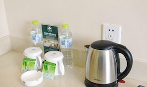 A kitchen counter with a kettle, bottled water, and tea packets. - Greentree Inn Chifeng Linxi Ronglin Homeland Express Hotel (Chifeng)