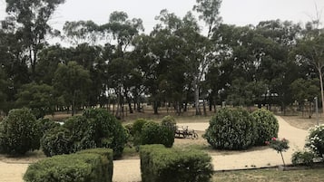 Stroll through the beautifully maintained garden, surrounded by lush trees and neatly trimmed hedges.