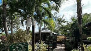 A pathway leading to a building with a sign indicating Sheridan Guesthouse Studios, 406-407. - Cozy Family Studio at Sheridan Guesthouse with Pool (Dania Beach)