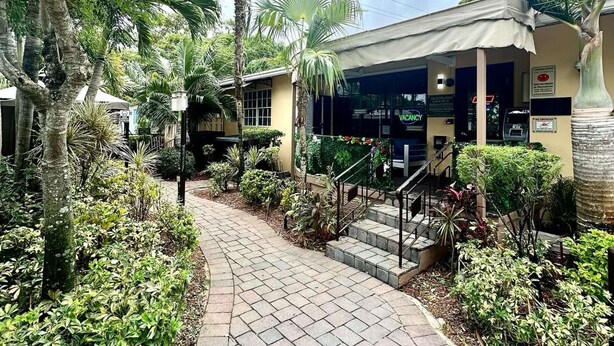 A pathway leading to a building with a sign indicating a vacancy. - Cozy Family Studio at Sheridan Guesthouse with Pool (Dania Beach)