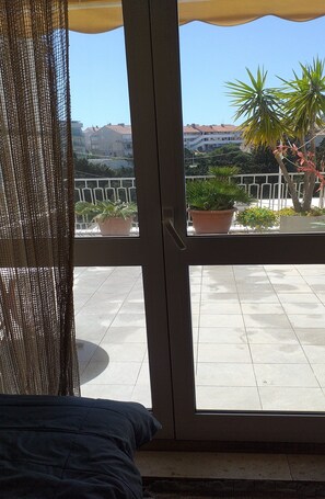 Enjoy a serene view from the balcony with potted plants and a clear view of the surrounding area.