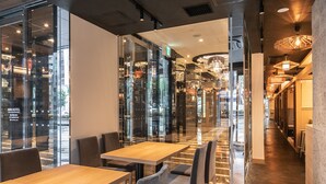 A modern hotel lobby with glass walls, a wooden reception desk, and a chandelier. - APA Hotel Osaka Temmabashi Ekimae (Osaka)