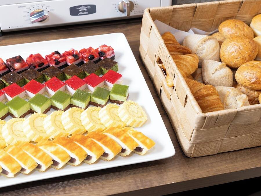 Variedad de postres y pasteles en una mesa, incluyendo pasteles en capas y pan.