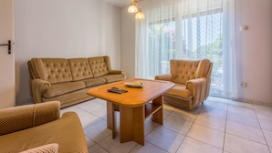 A living room with a sofa, armchair, and coffee table. - Apartment Eugen (Crikvenica)