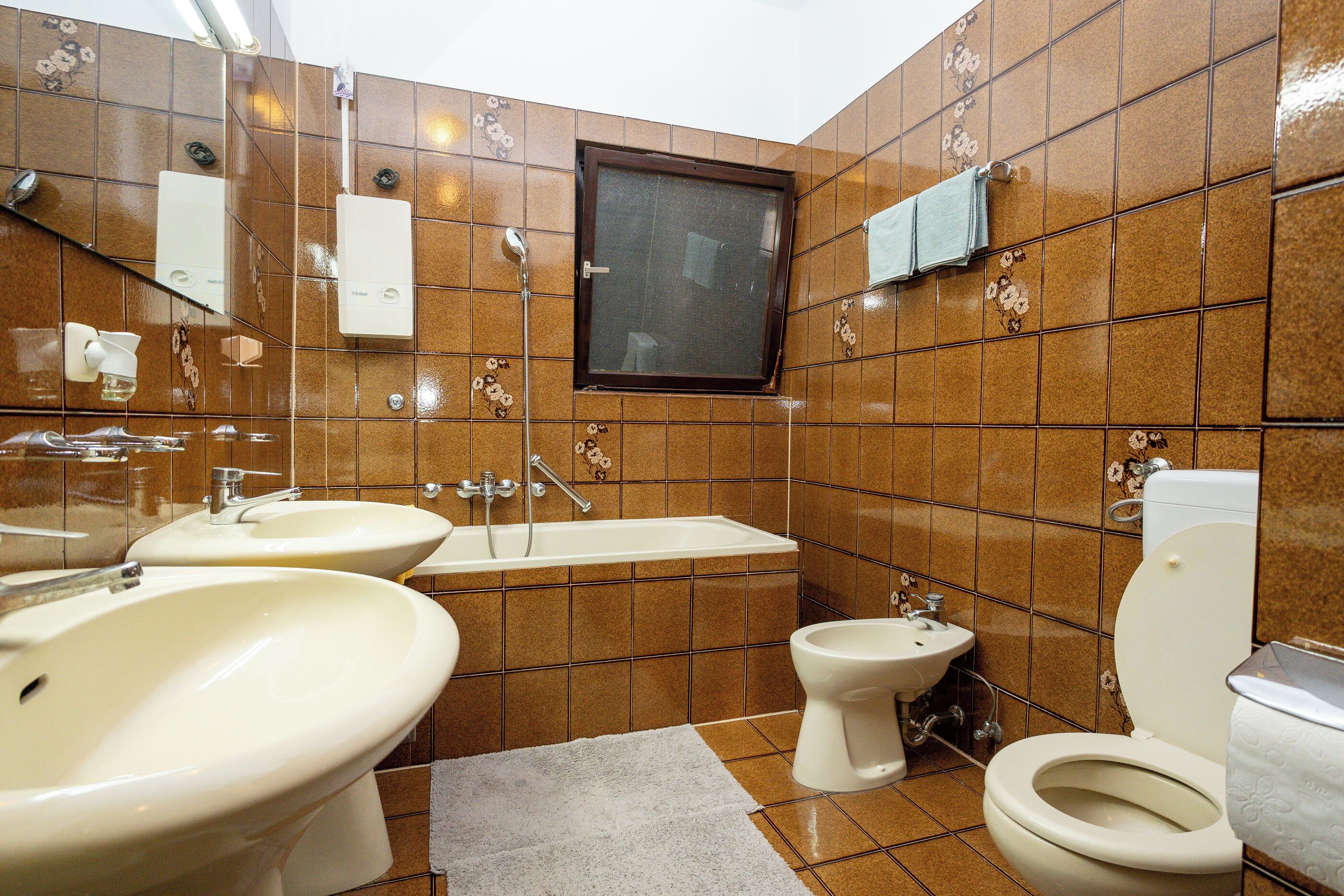 A bathroom with two sinks, a shower, a toilet, and a towel rack.
