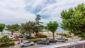 Un’area di parcheggio con auto e un sentiero pedonale vicino alla spiaggia.