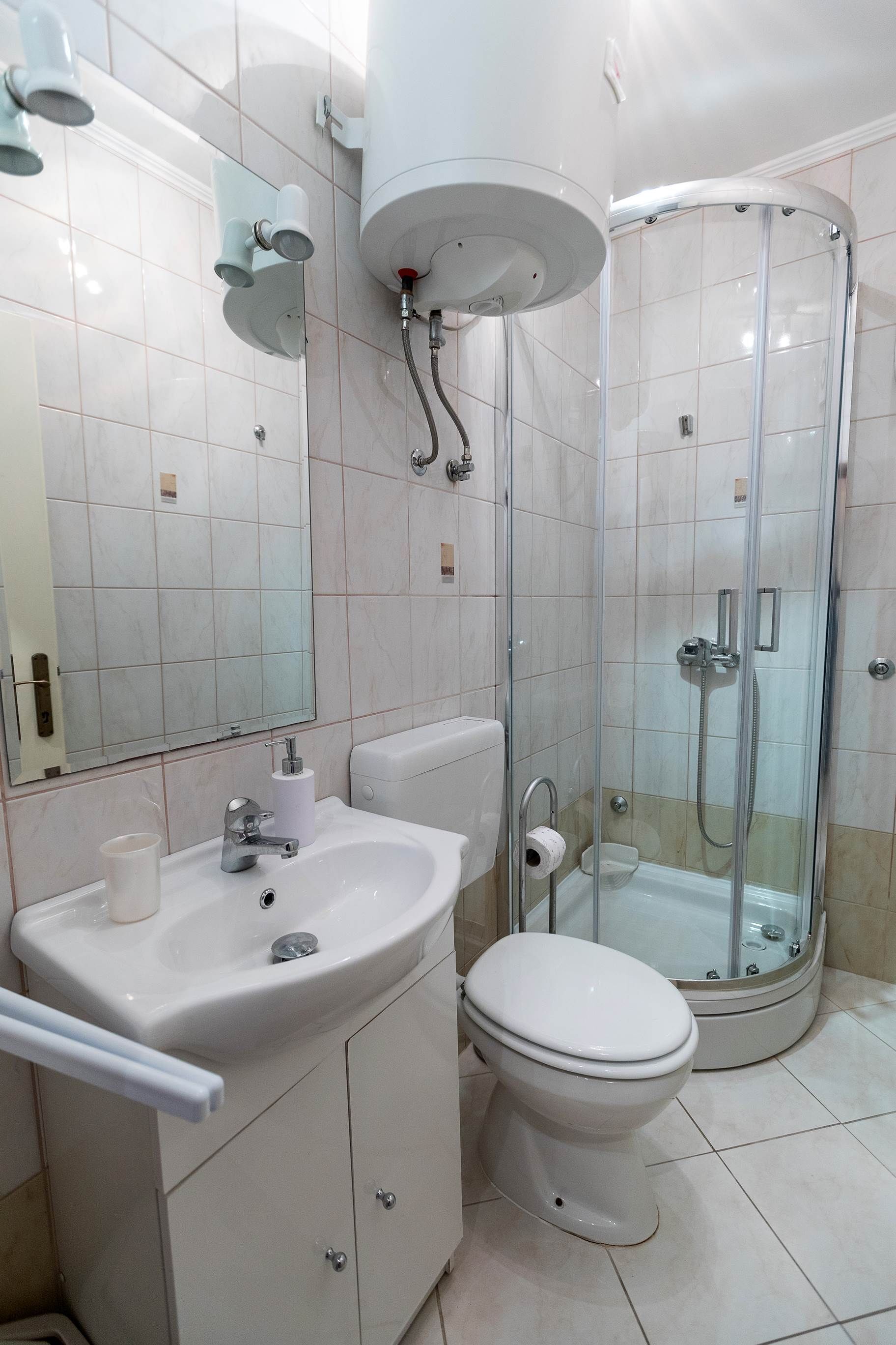 A modern bathroom with a sink, toilet, and glass-enclosed shower.