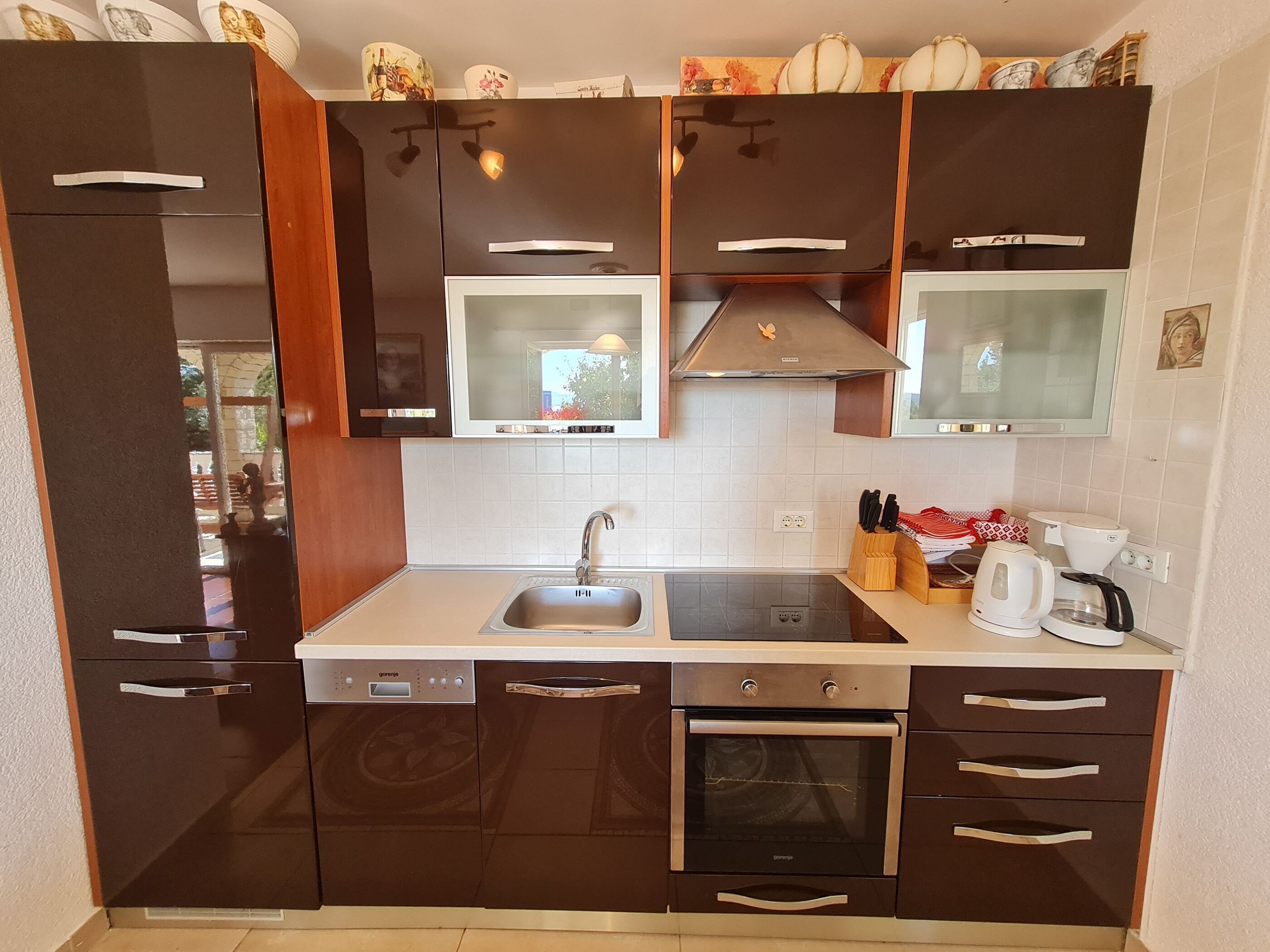 Una cocina compacta con lavavajillas, horno, fregadero y microondas.