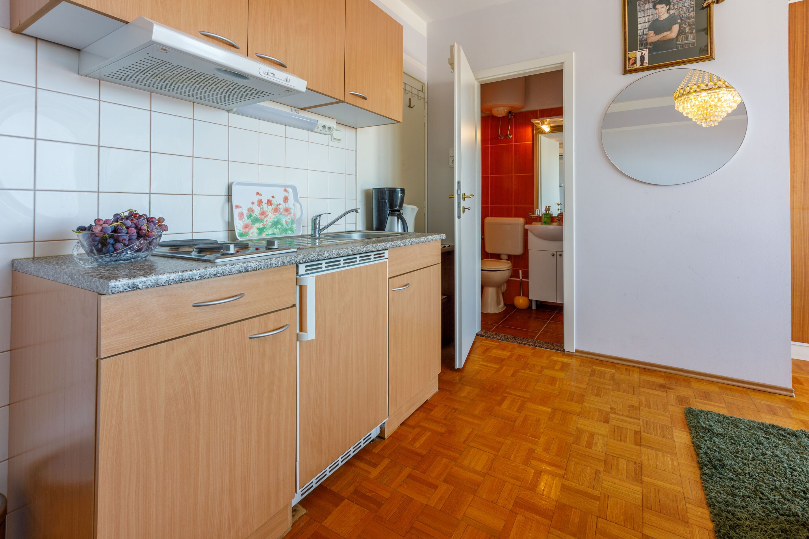 A modern kitchen with wooden cabinets, a granite countertop, and a built-in dishwasher.