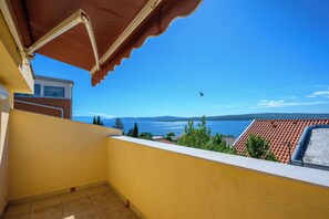 A balcony with a view of the sea and mountains.