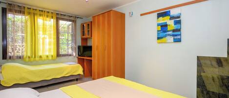A room with a bed, a desk, a wardrobe, and a painting on the wall.