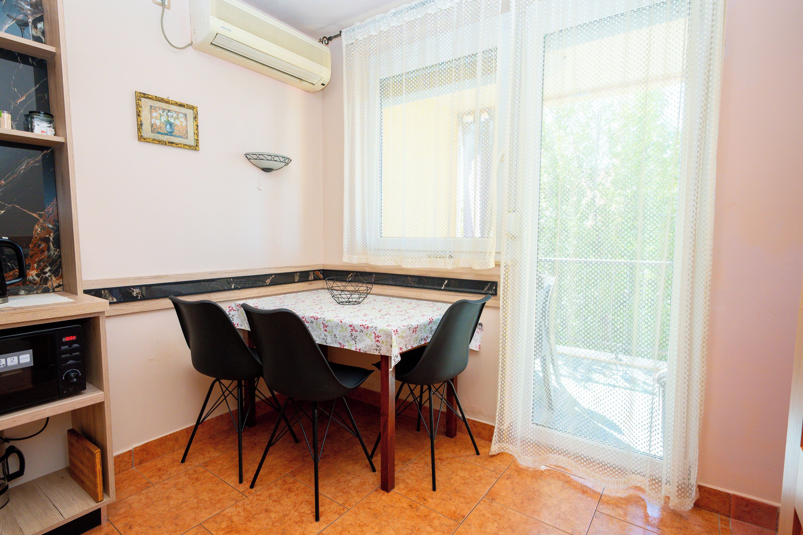 Une petite cuisine équipée d’une table à manger, de chaises et d’un four à micro-ondes.