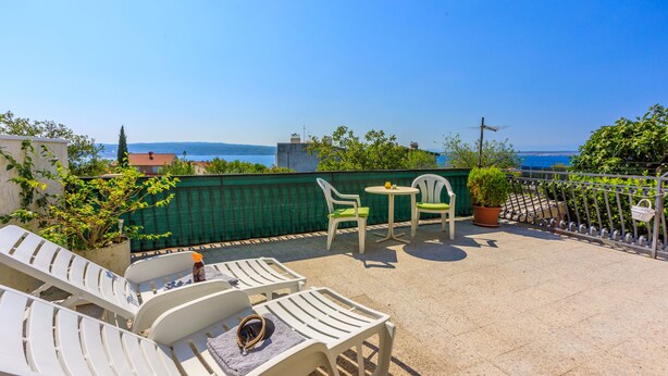 A rooftop terrace with white lounge chairs, a small table, and a potted plant. - Apartments Alex (Crikvenica)