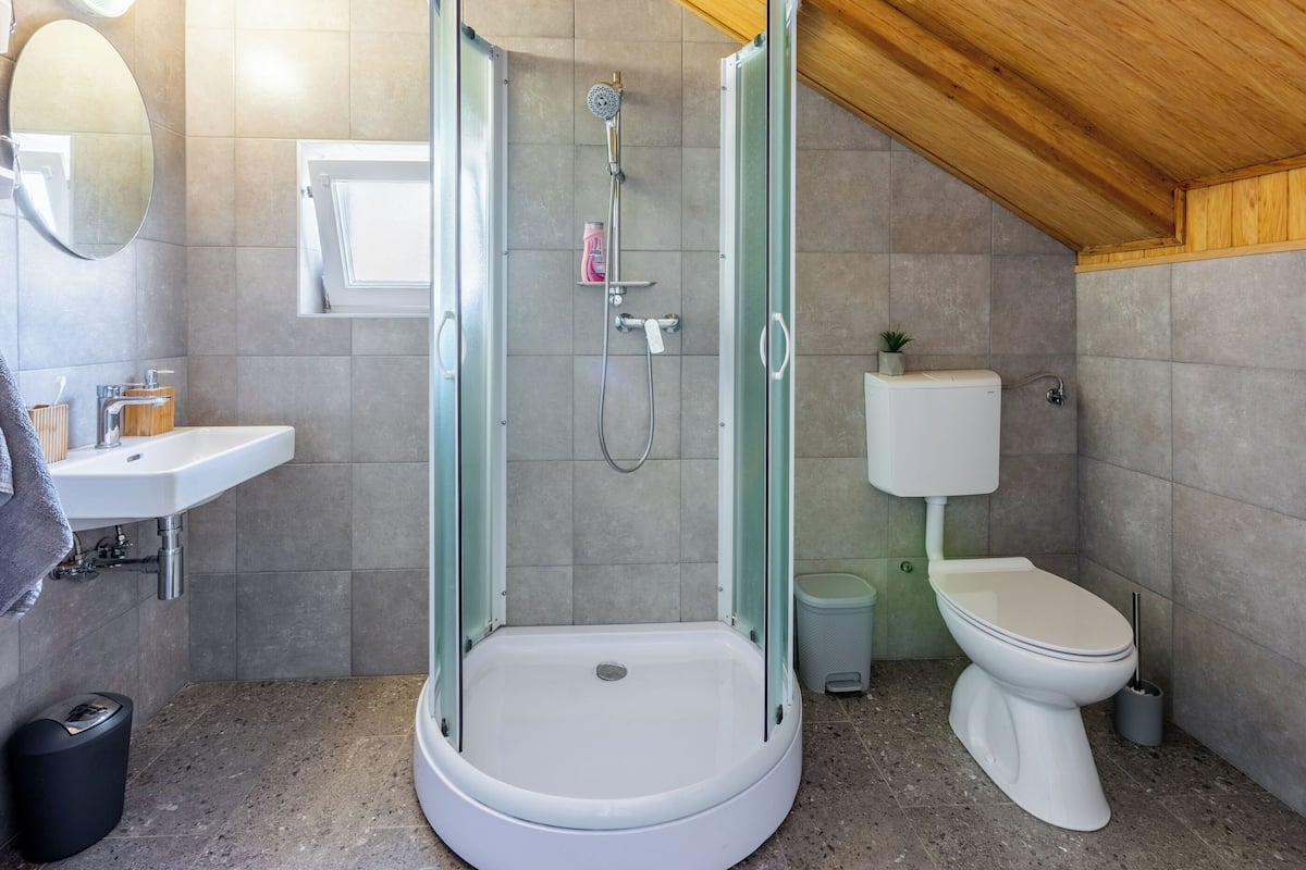 Une salle de bain moderne avec une douche à parois de verre, un lavabo blanc et des toilettes.