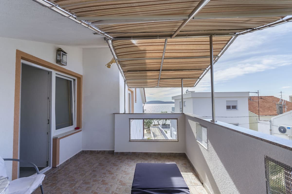 Ein Balkon mit Blick auf Gebäude und ein Gewässer.