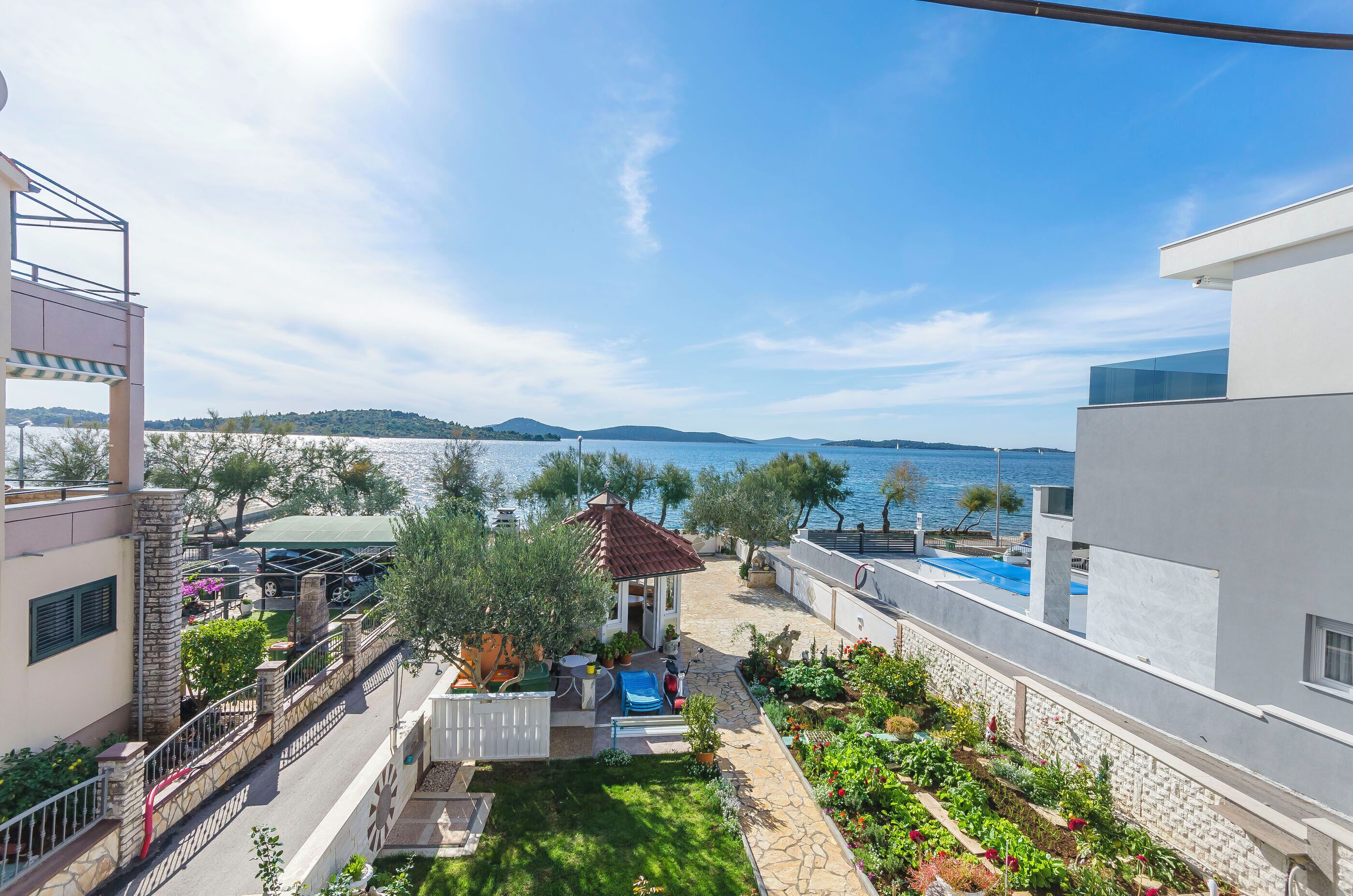 A residential property with a patio, a small garden, and a view of the sea.