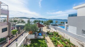 A residential property with a patio, a small garden, and a view of the sea. - Apartments Ivanka on the Beach (Vodice)