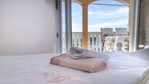 A hotel room with a bed, a window, and a balcony with chairs. - Apartments Ivanka on the Beach (Vodice)