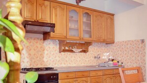 A kitchen with wooden cabinets, a stove, and a sink. - Apartment Anica (Starigrad - Paklenica)