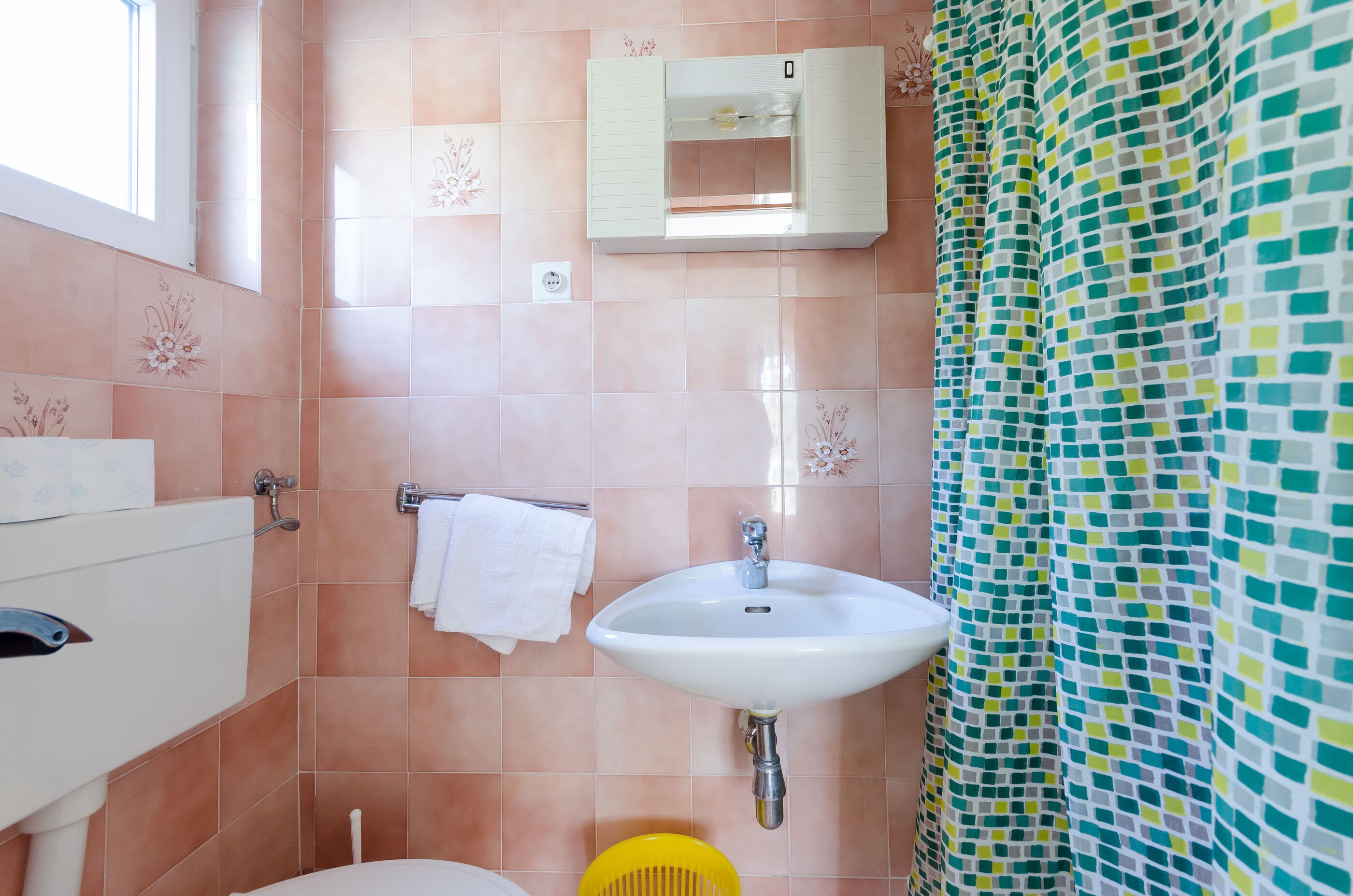 Un baño con lavabo, inodoro y ventana.