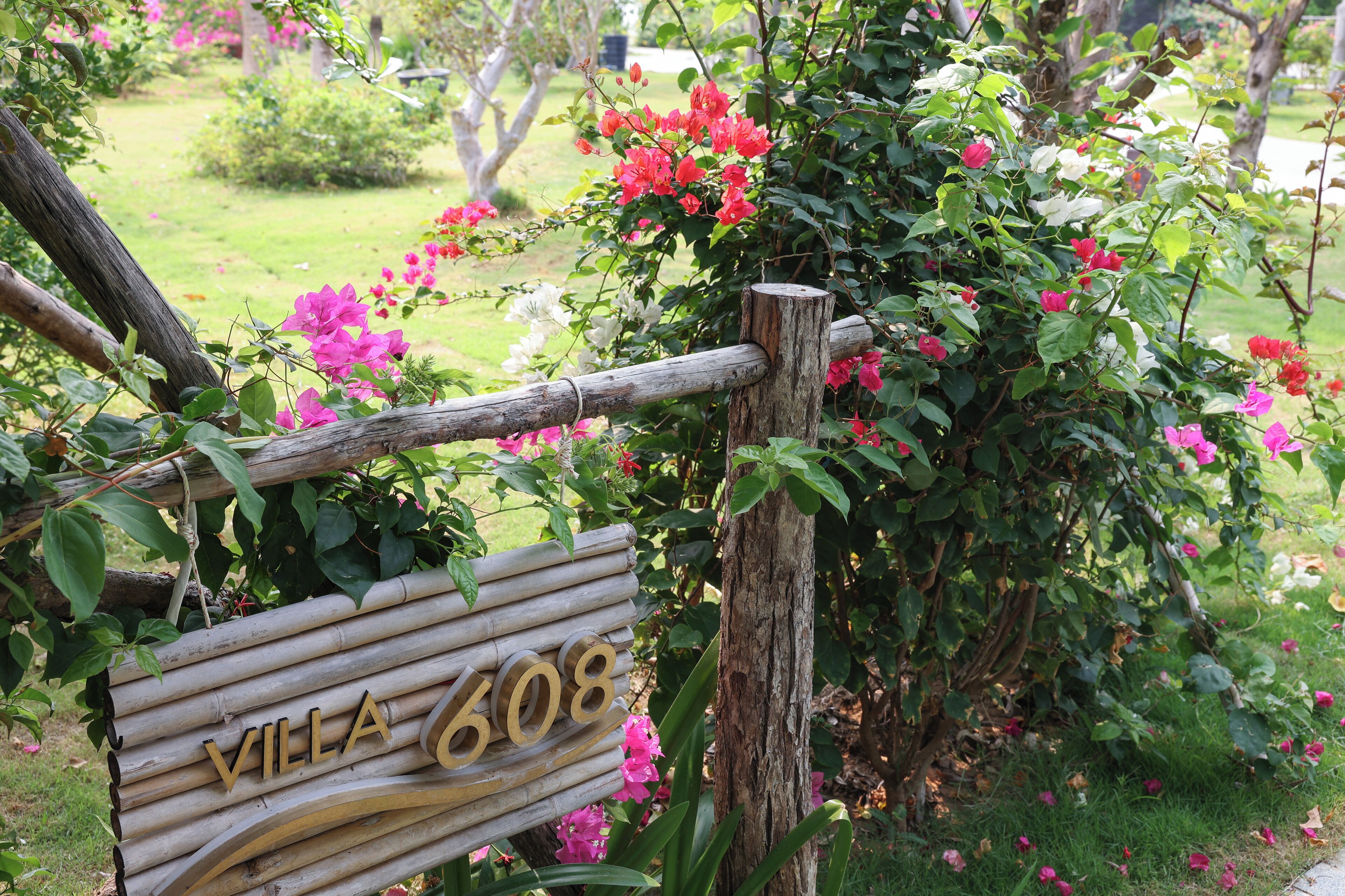 A wooden sign with "VILLA 608" indicating a property name.