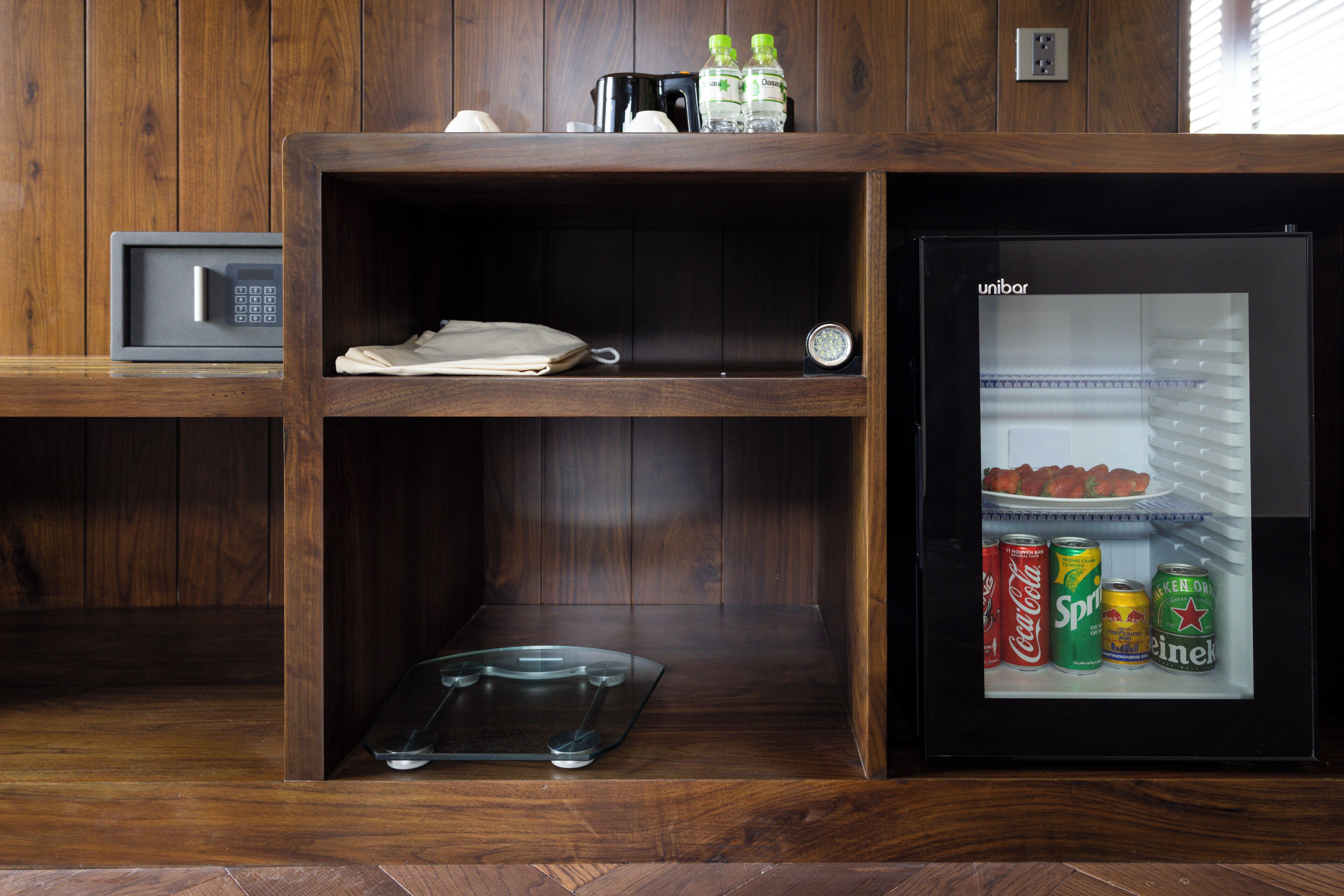 A compact kitchen with a microwave, a coffee maker, and a refrigerator containing beverages.