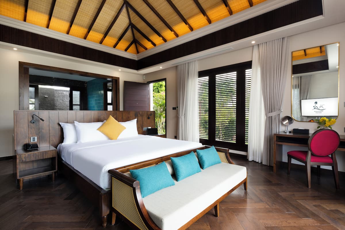A spacious bedroom with a large bed, a desk, and a chair.