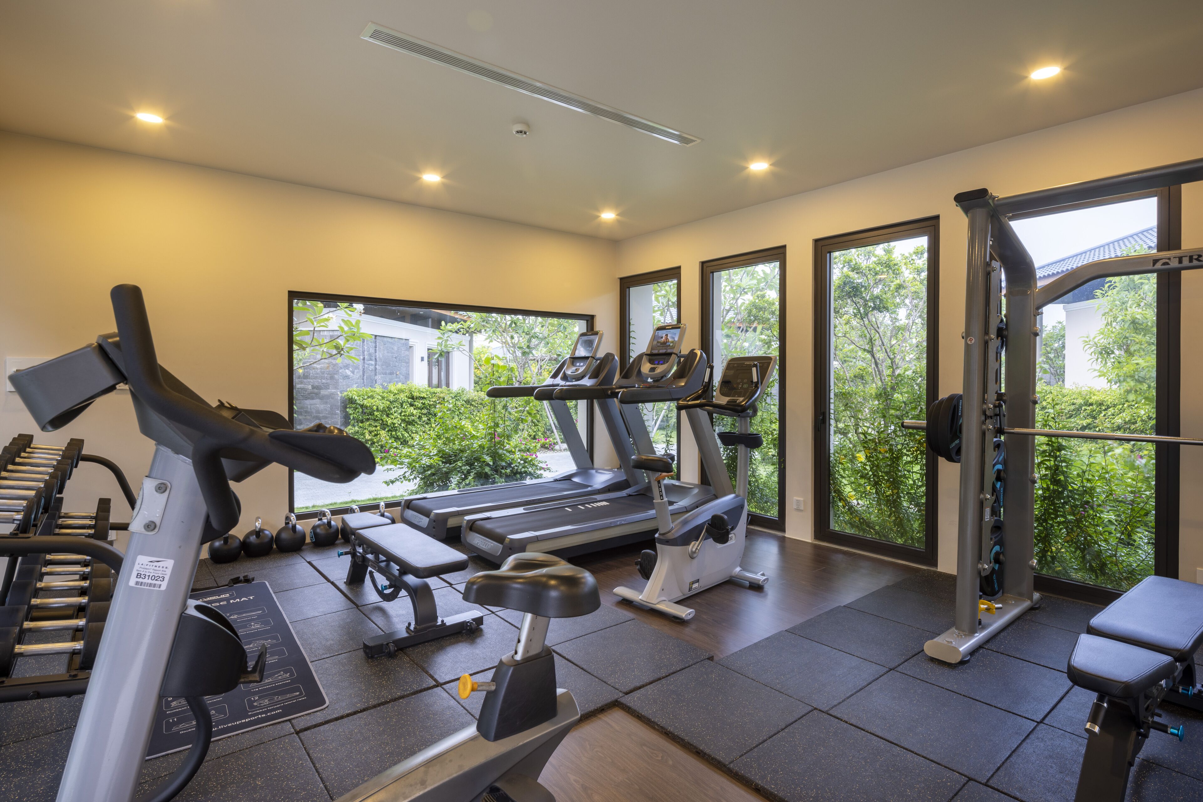 A gym with treadmills, weight machines, and a rowing machine.
