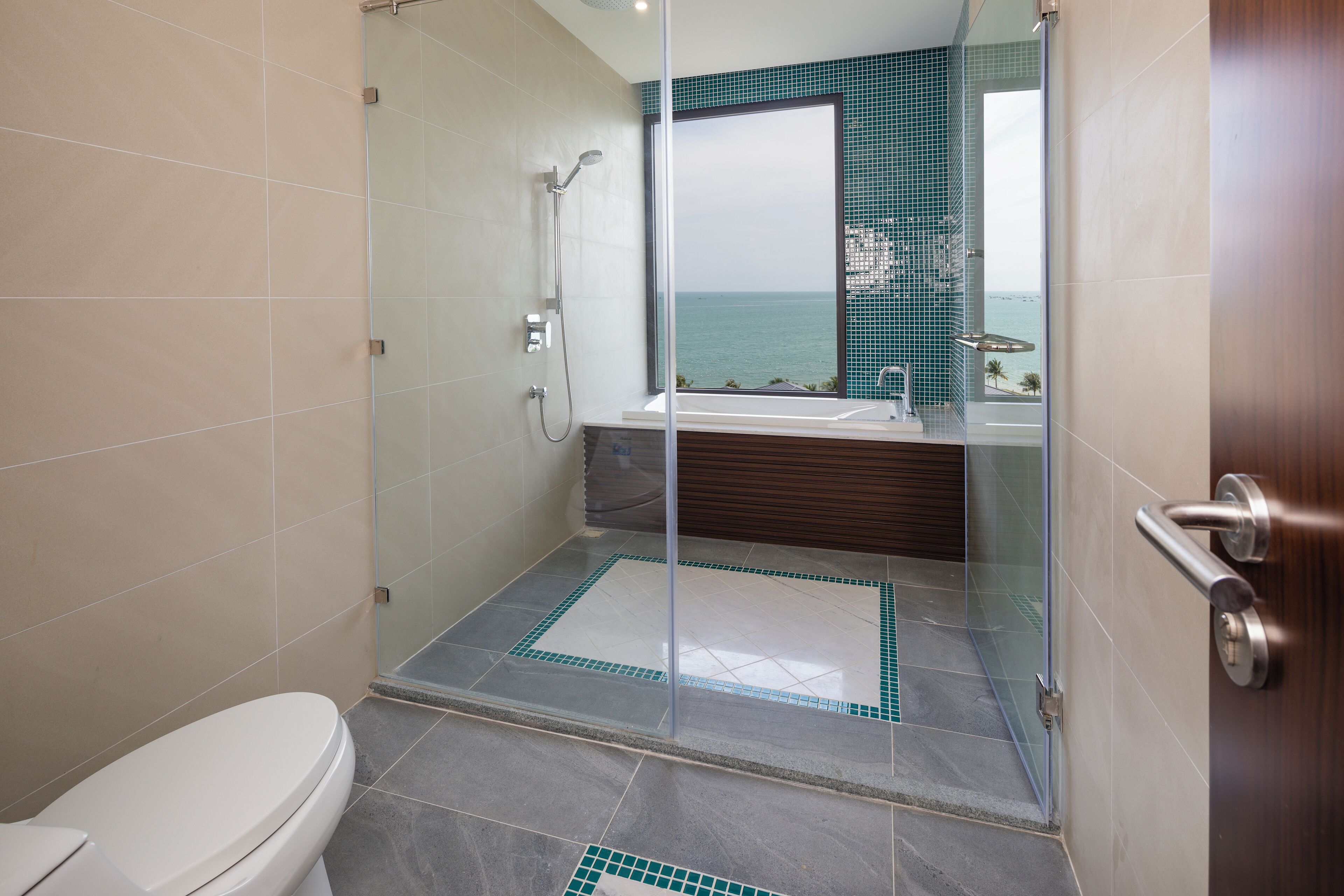 A modern bathroom with a glass-enclosed shower, a toilet, and a bathtub.