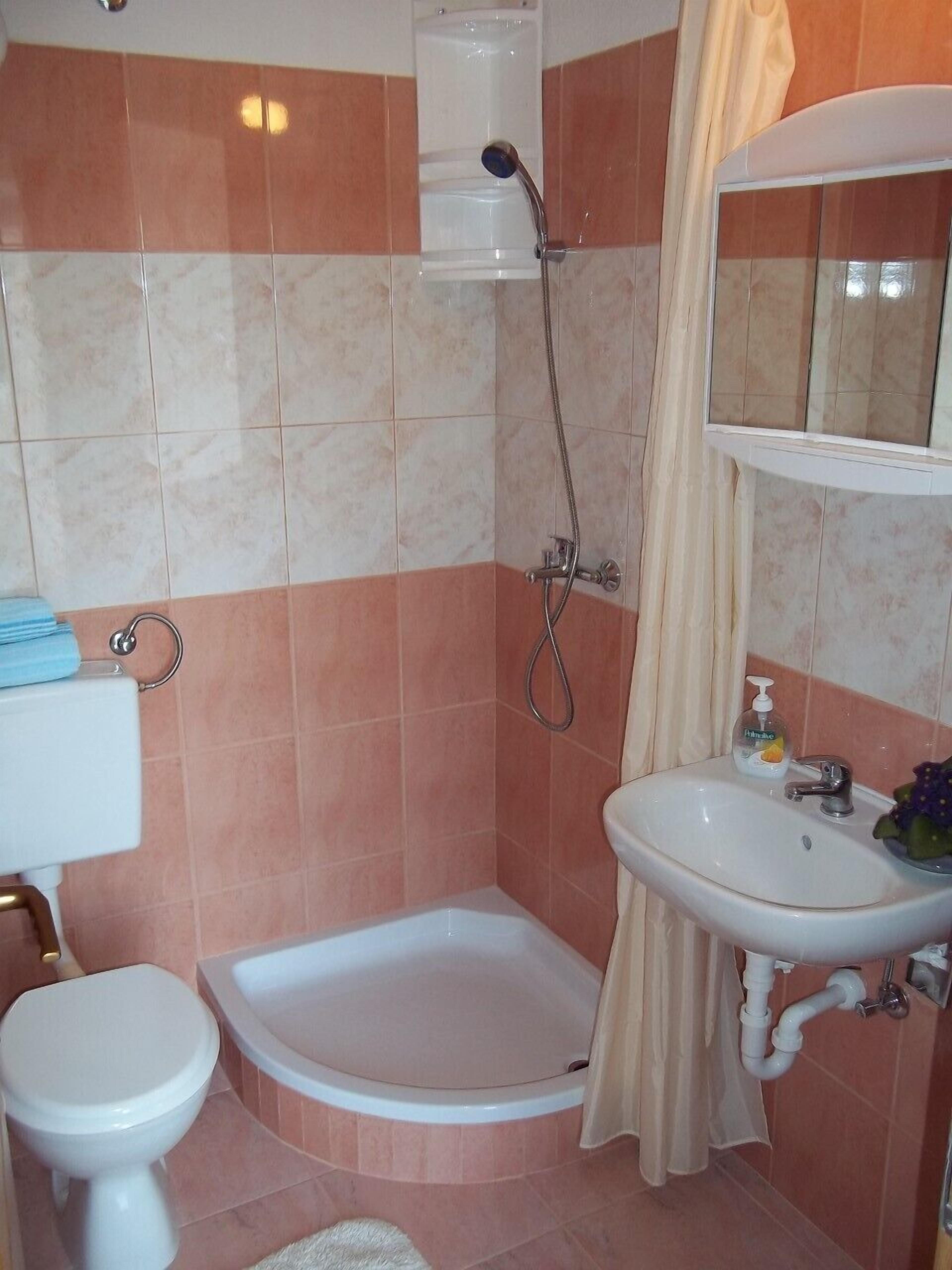 Ein Badezimmer mit Dusche, Toilette und Waschbecken.